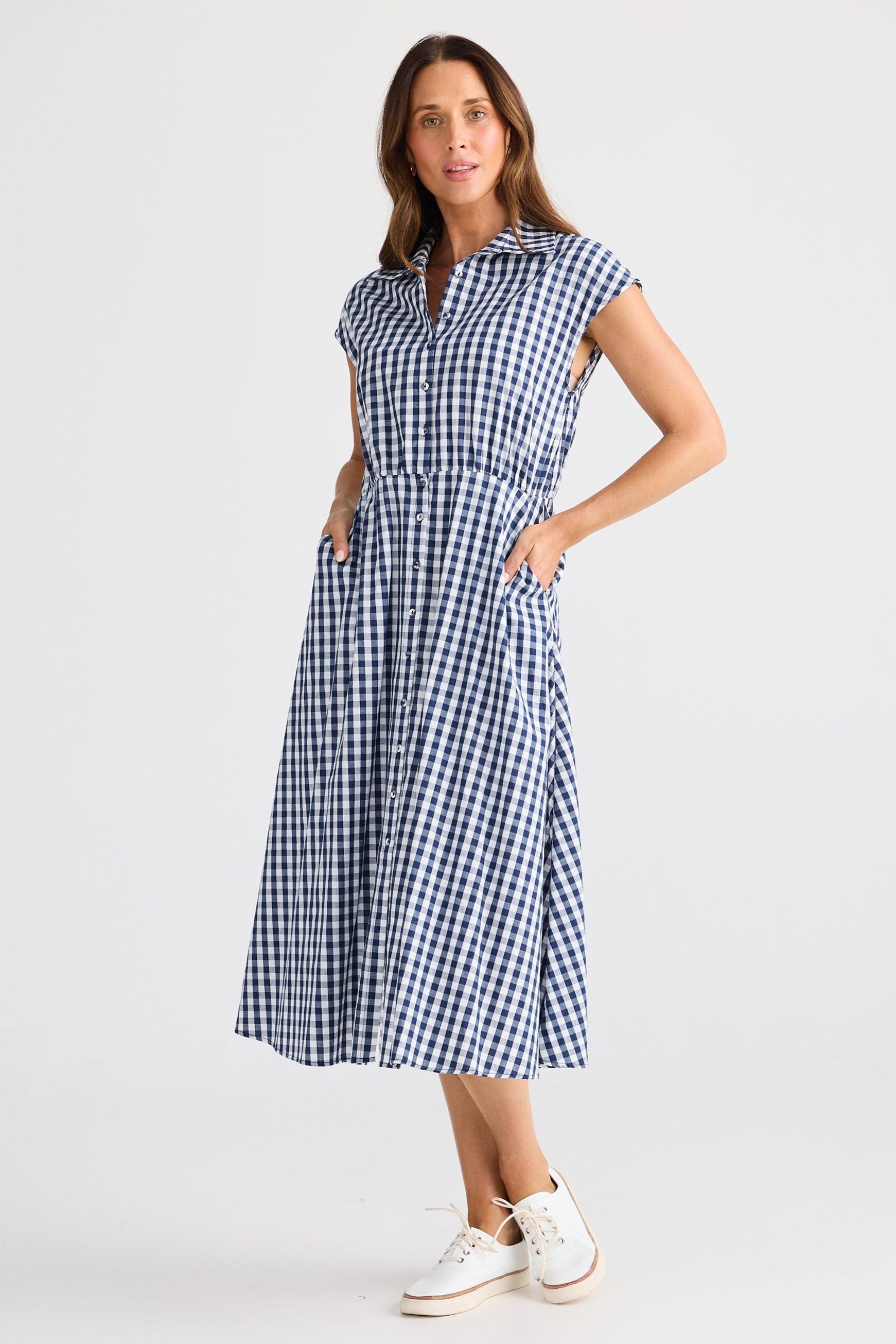 Woman wearing a blue and white checkered dress on a white background